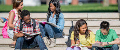 An image of a group of students sitting outside on the steps.