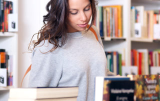 A photo of a young woman looked at books on display in a store or library