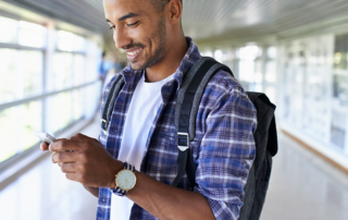 An image of a young man looking at his cellphone.