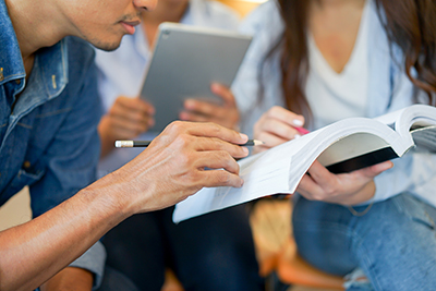 An image of a group of students reviewing notes in a textbook.